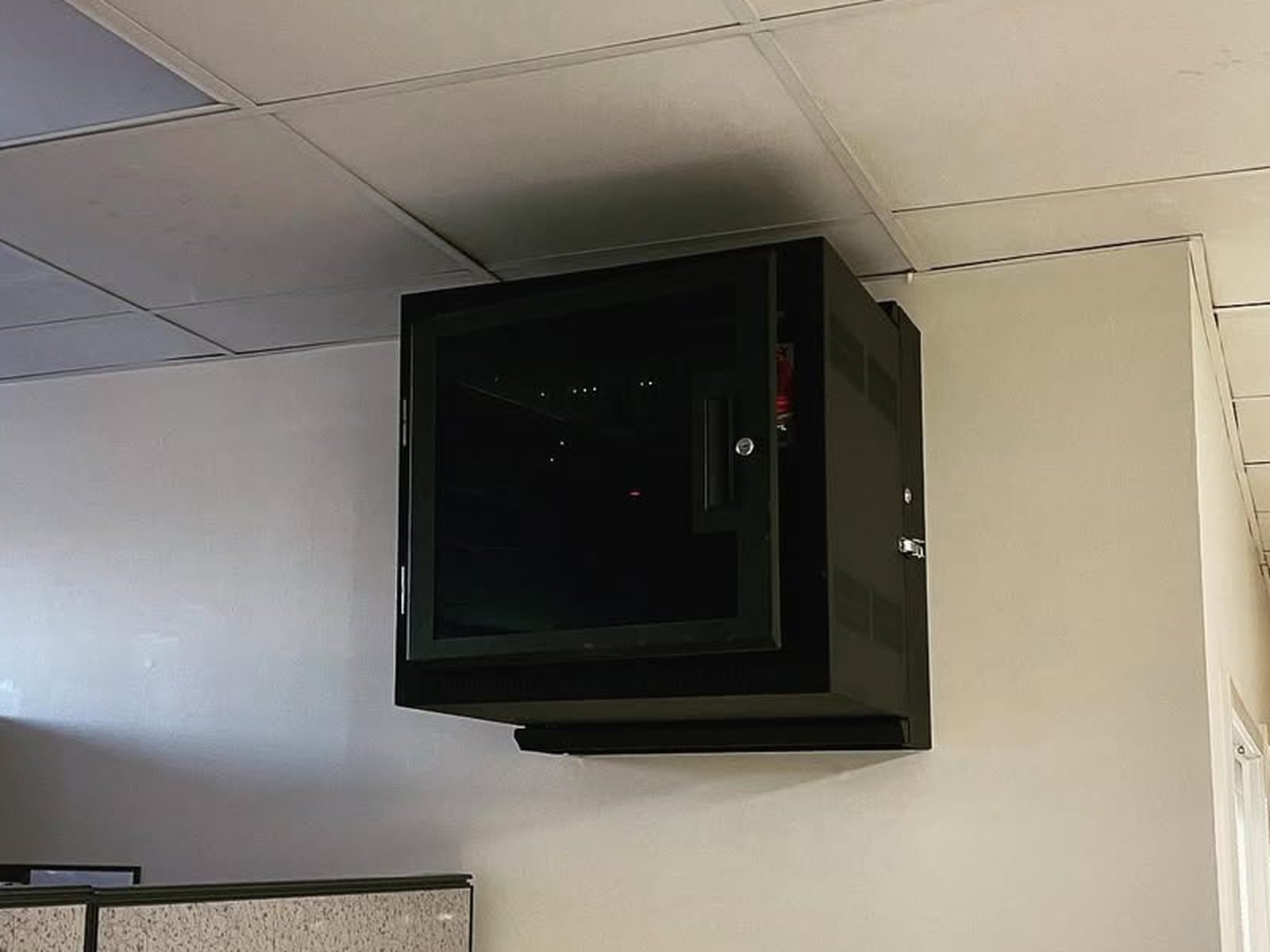 Wall-mounted network cabinet installed and closed in a finished commercial office